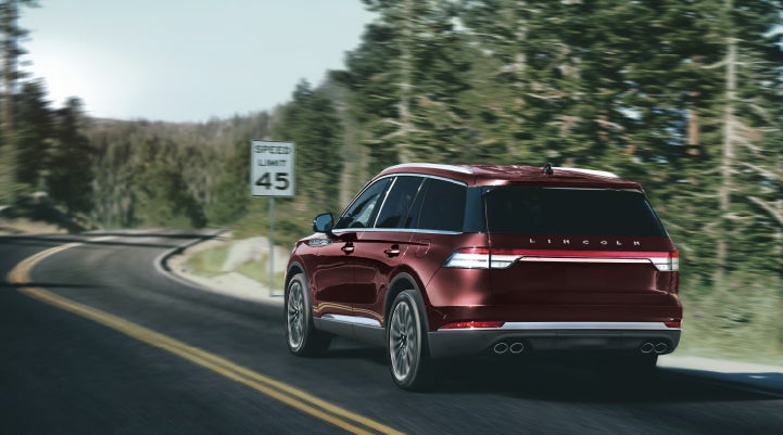 A 2024 Lincoln Aviator® SUV is being driven on a winding mountain road | Jenkins & Wynne Lincoln in Clarksville TN